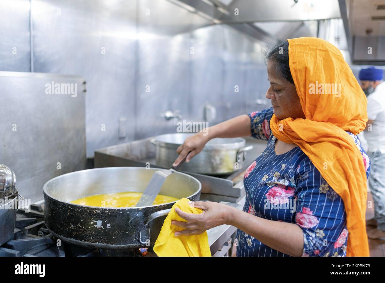 Eine Freiwillige in einer Gemeinschaftsküche von Sikh Langar kocht ein vegetarisches Gericht, um Gläubige, Besucher und Fremde zu füttern. In einem Tempel in Queens, New York City. Stockfoto