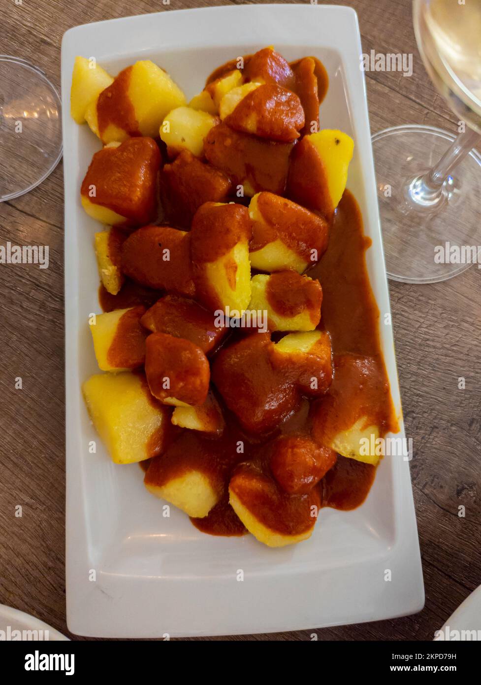 Typisch spanisches Gericht namens Patatas bravas, gebratene Knollen mit roter scharfer Sauce mit Zwiebeln, Paprika, Oregano, Chili Stockfoto