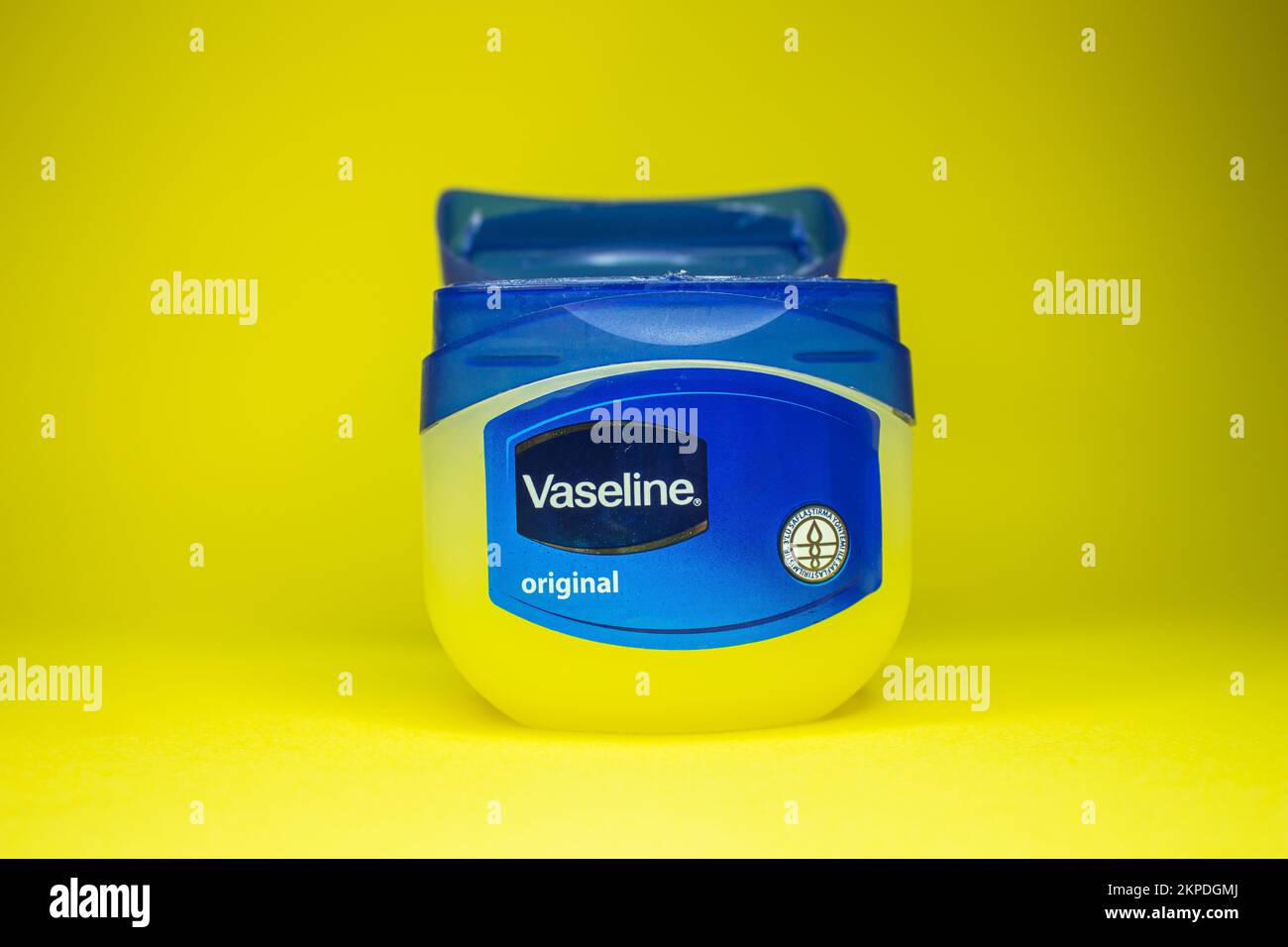 Vaseline-Flasche auf gelbem Hintergrund. Hautpflegemittel Vaseline oder Vaseline. Afjonkarahisar, Türkei - 19. November 2022. Stockfoto