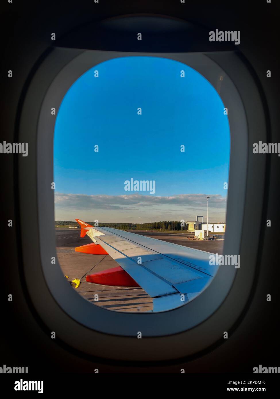 Ein Flugzeugfenster mit Blick auf den Flügel der Landebahn Stockfoto