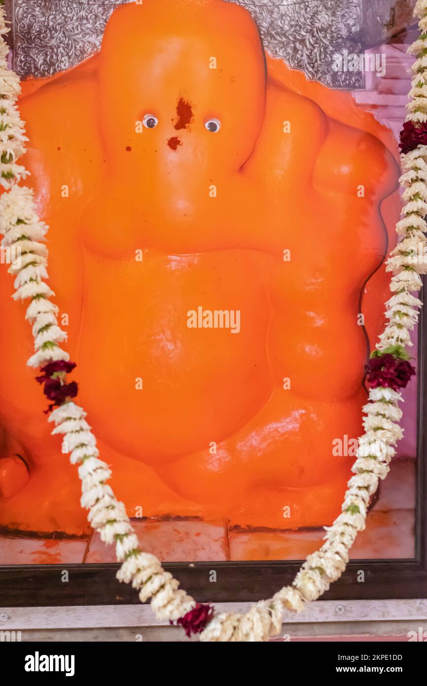 der hinduistische gott ganesha-Idol, das mit Blumen verehrt wird, wird im ganesh-Tempel ratanada jodhpur rajasthan india in vertikaler Schussrichtung aus einem flachen Winkel aufgenommen. Stockfoto