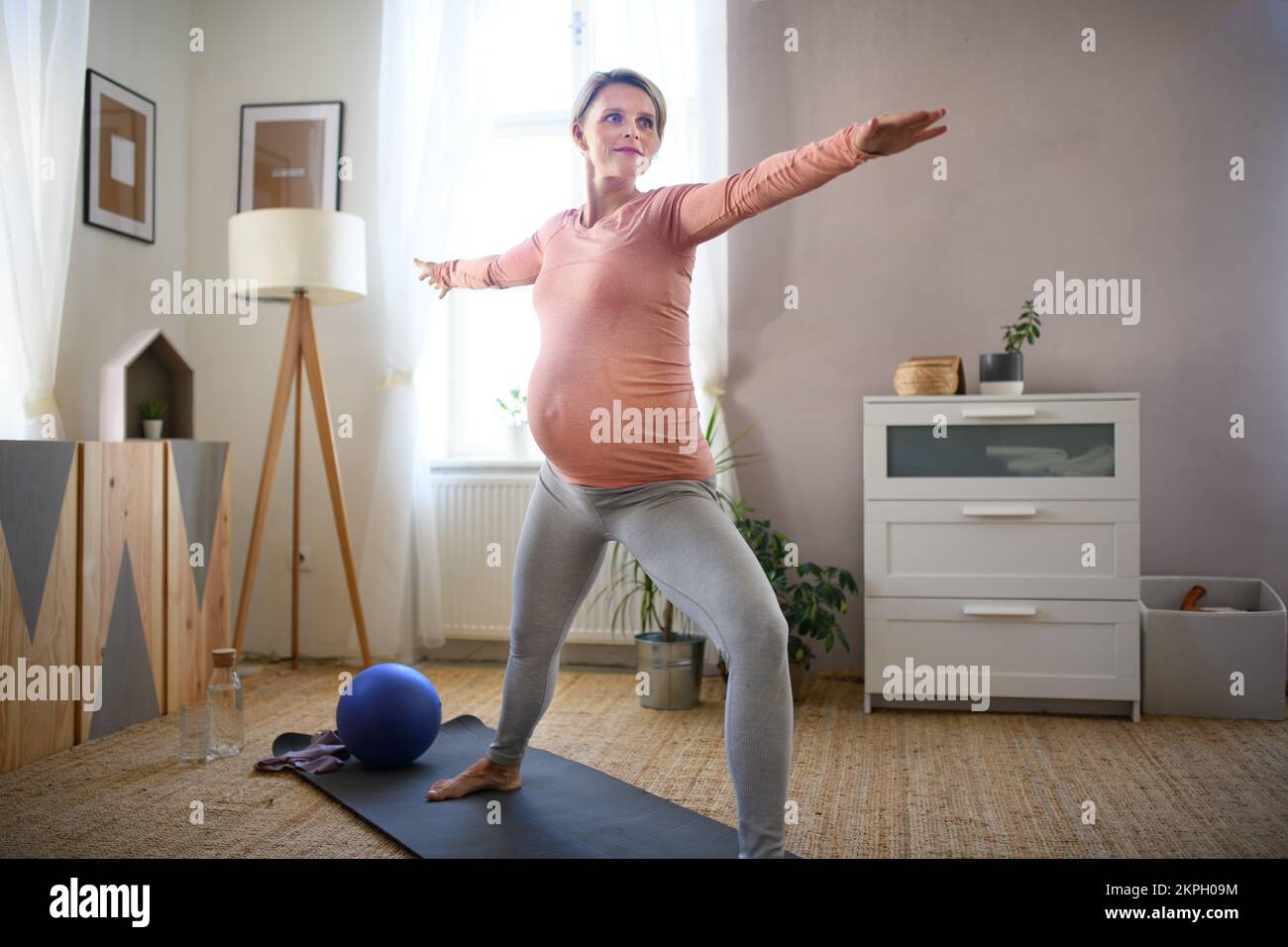 Schwangere Frau macht Übungen in ihrer Wohnung. Stockfoto