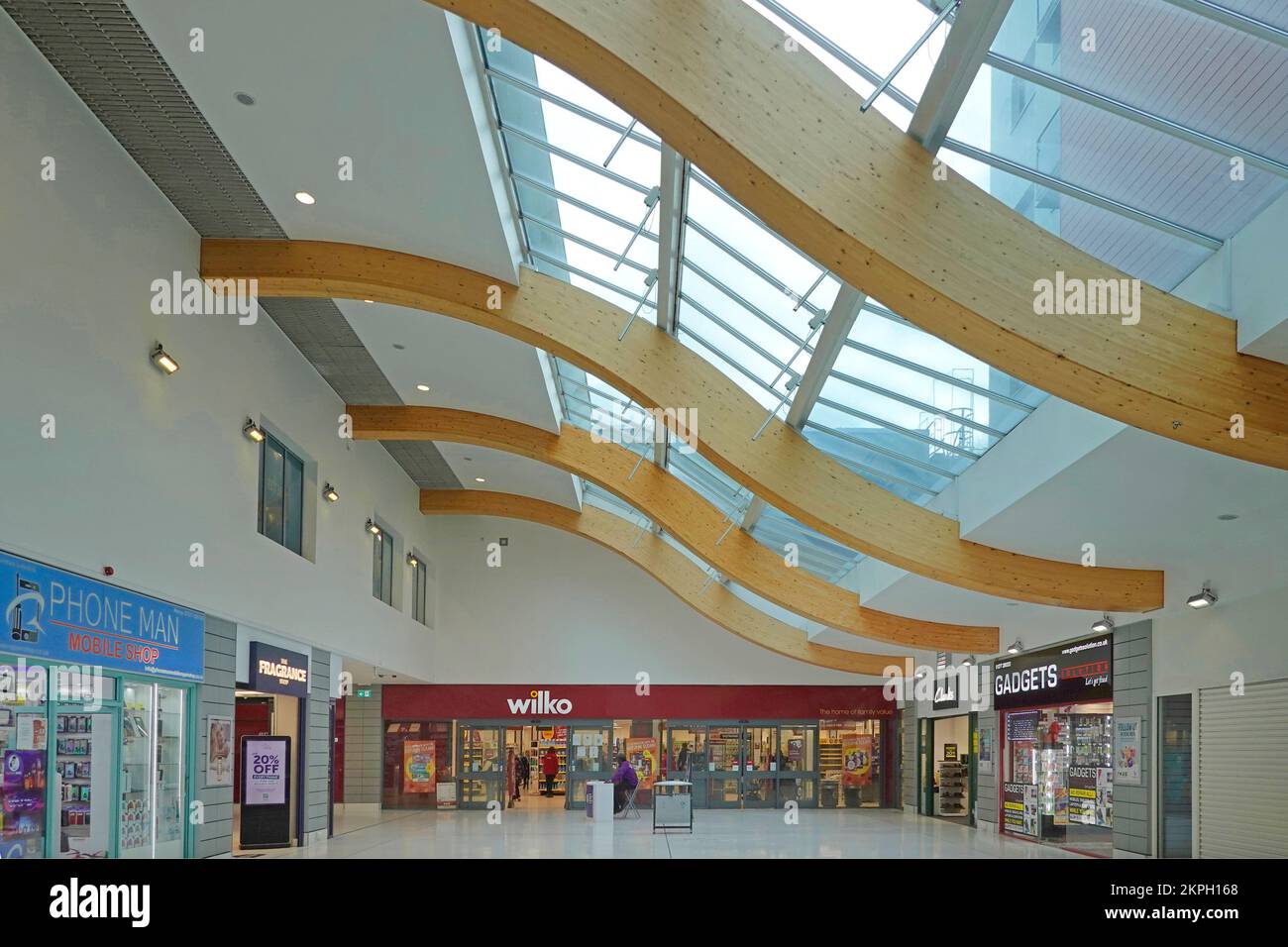 Dachbalken aus geschwungenem, glulambeschichtetem Holz, die das Glasdach eines modernen Einkaufszentrums in der Innenstadt stützen, Essex England UK Stockfoto