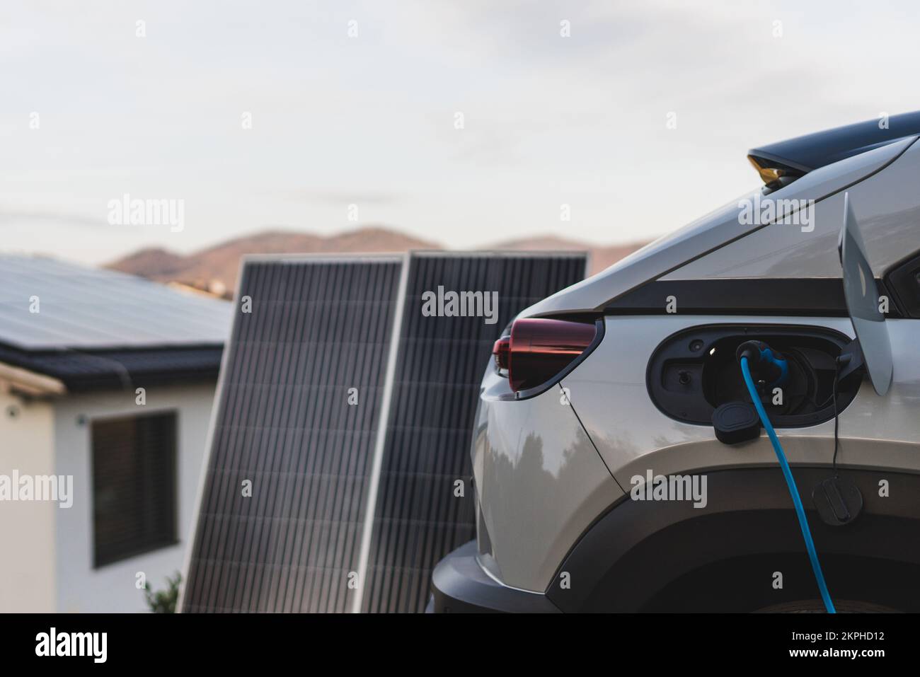 Laden eines Elektroautos aus dem heimischen Photovoltaik-Kraftwerk, nachhaltiges und wirtschaftliches Transportkonzept. Stockfoto
