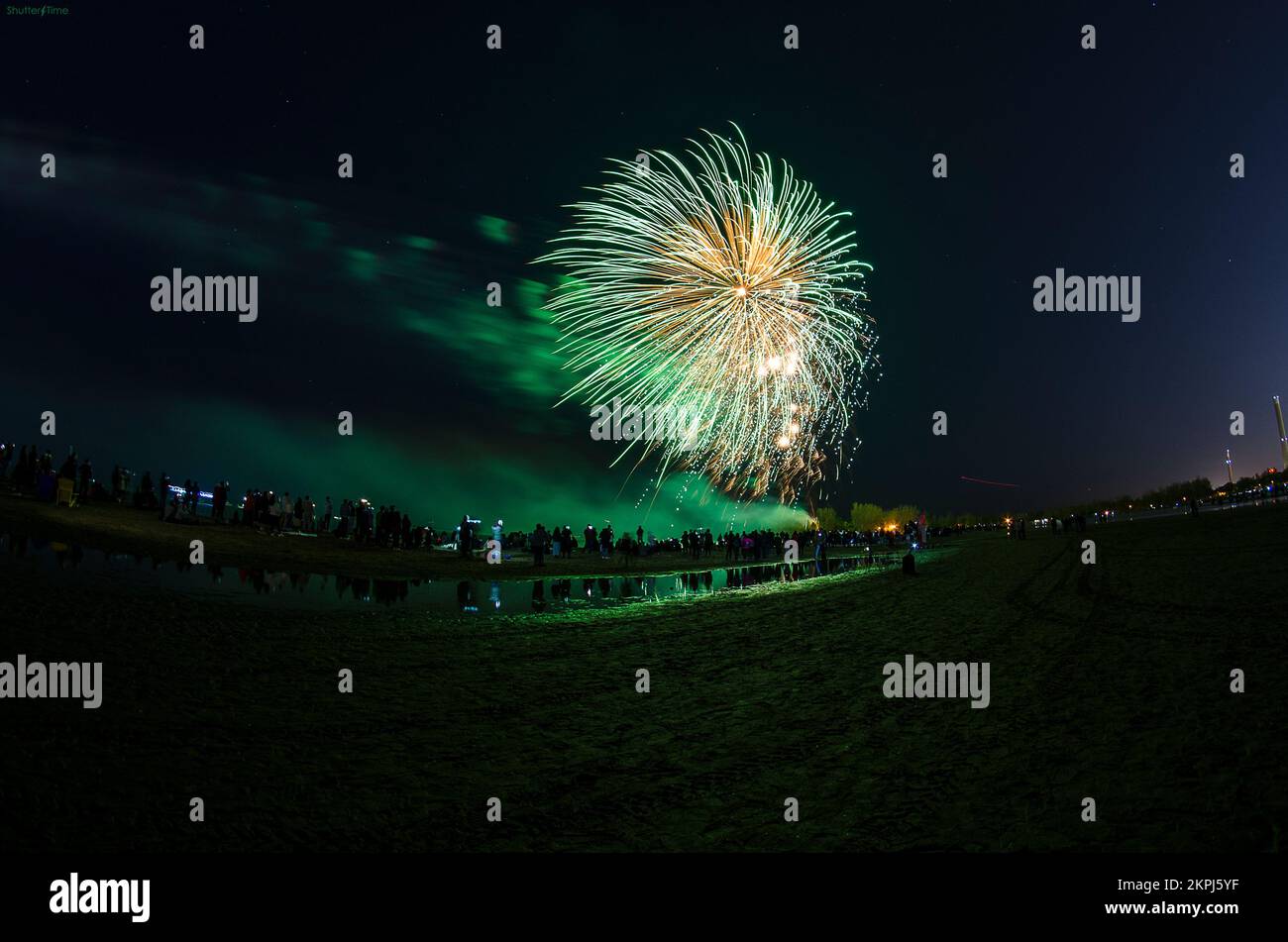Grünes Feuerwerk am Strand Stockfoto