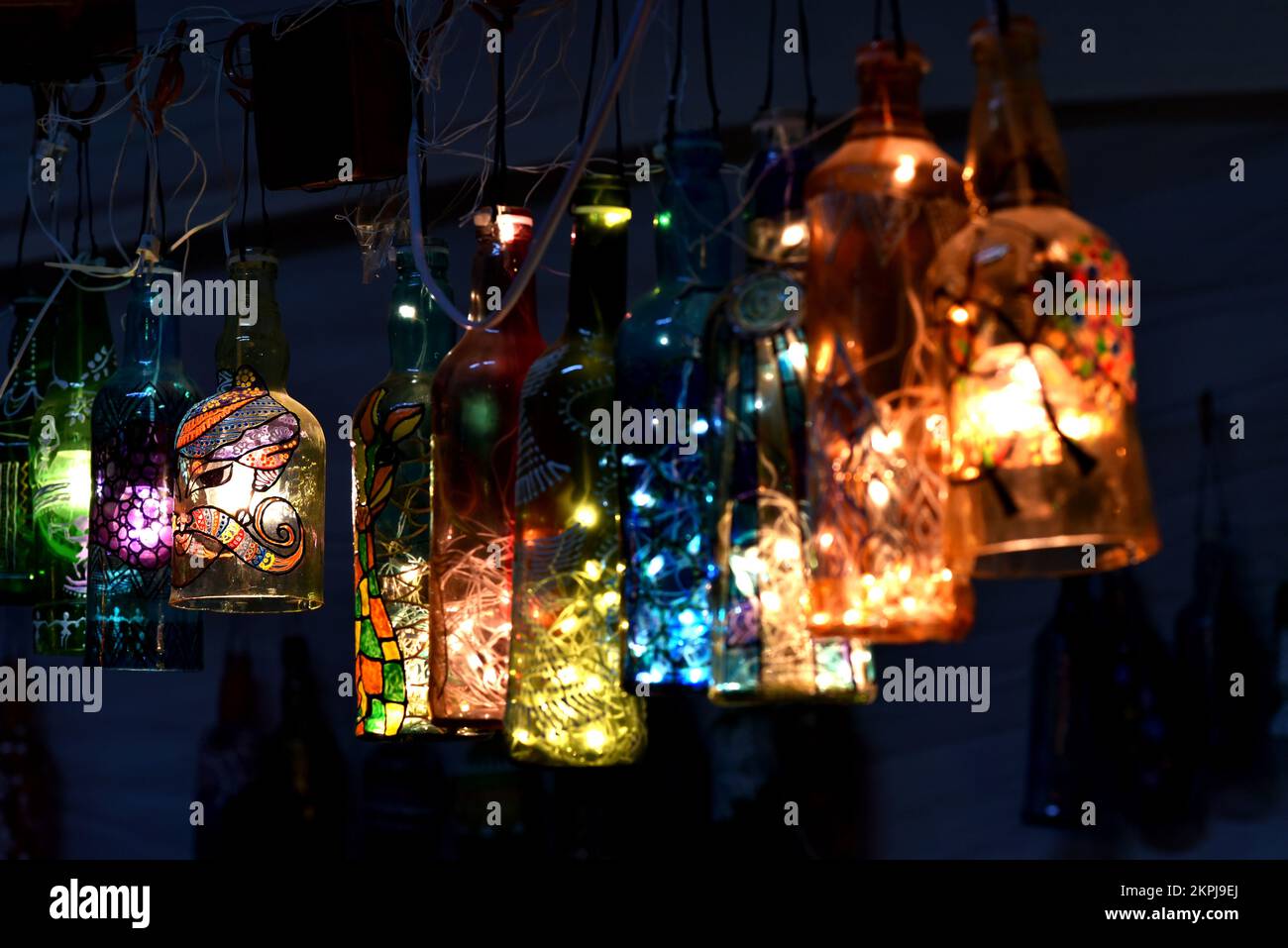 Hängende Lampen aus weggeworfenen Flaschen. Inneneinrichtung mit bemalter Flaschenkunst und Kunsthandwerk. Stockfoto