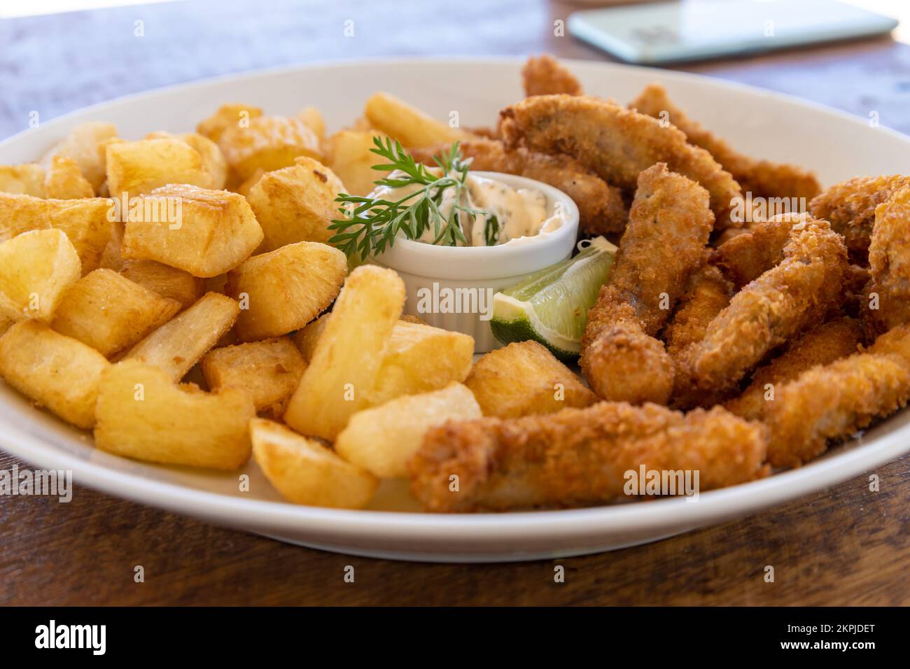 Kassava und gebratener Fisch auf einem Teller. Lebensmittel mit hohem Kalorienwert. Stockfoto