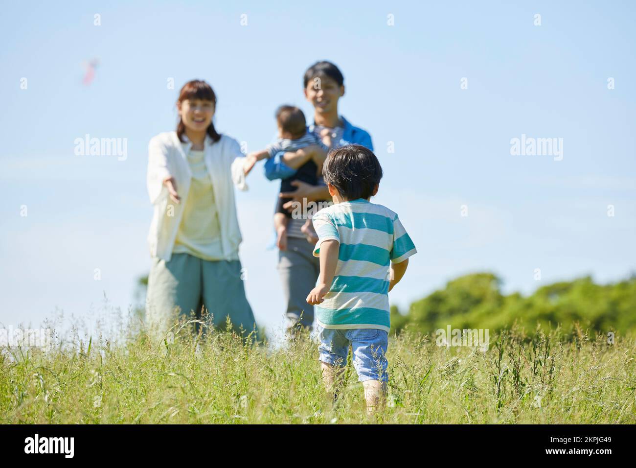 Japanische Eltern, die auf das laufende Kind aufpassen Stockfoto