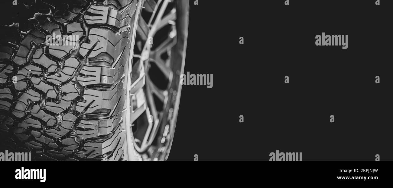 Hochleistungs-Reifenprofil auf schwarzem Hintergrund mit Kopierbereich für Banner, Fahrzeugwartung. Stockfoto