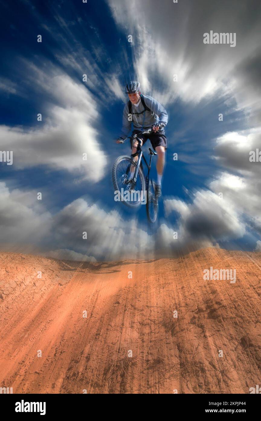 Ein Mountainbike-Mann, der draußen unterwegs ist und sich mit dem Himmel und der Zoom-Bewegung auf den Schmutz stürzt Stockfoto