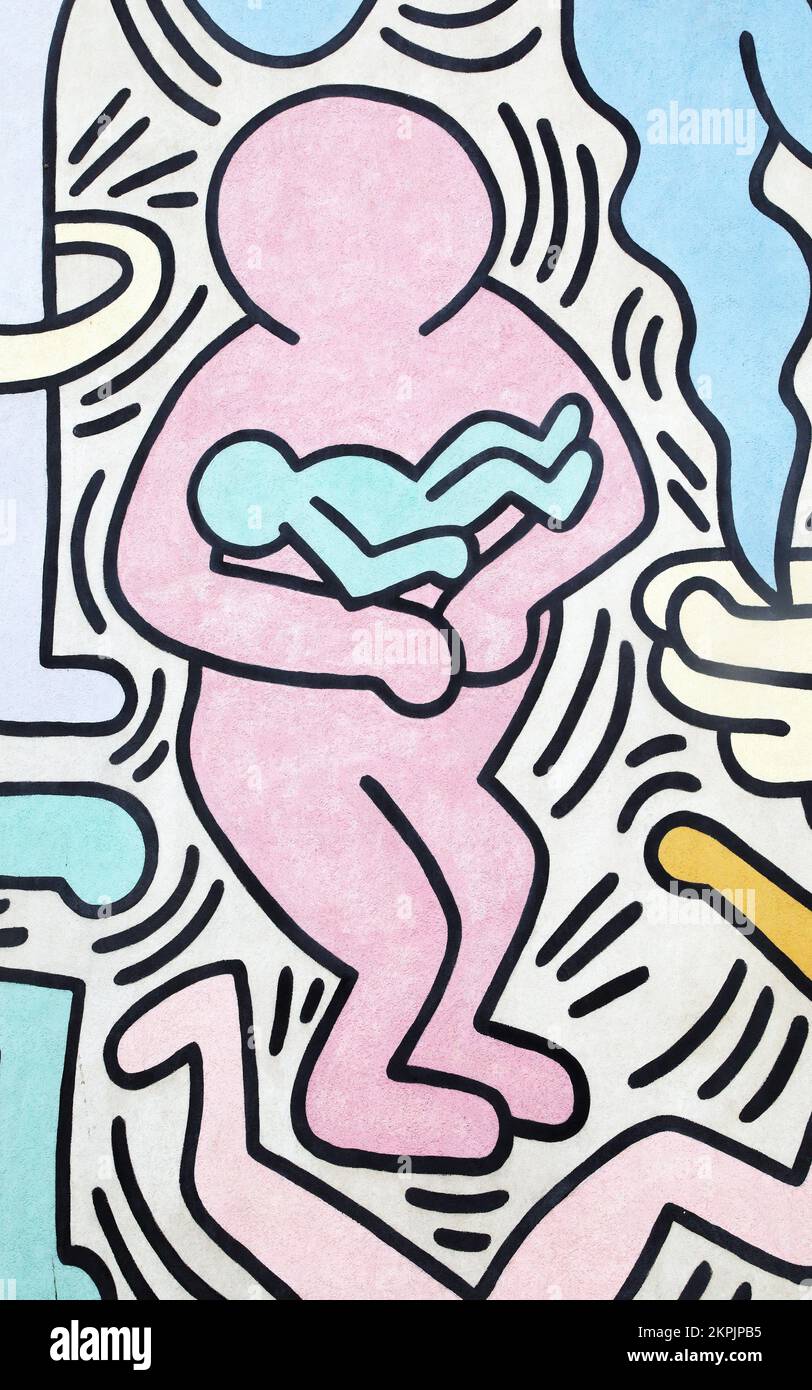 Mann mit einem Baby, gemalt von Keith Haring in Pisa. Details aus einem Wandgemälde namens Tuttomondo, das 1989 im Freien erschaffen wurde. Stockfoto