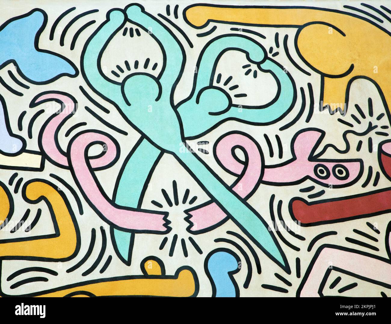 Eine Schere schneidet eine Schlange, gemalt von Keith Haring. Details aus einem Wandgemälde namens Tuttomondo, das 1989 im Freien erschaffen wurde Stockfoto