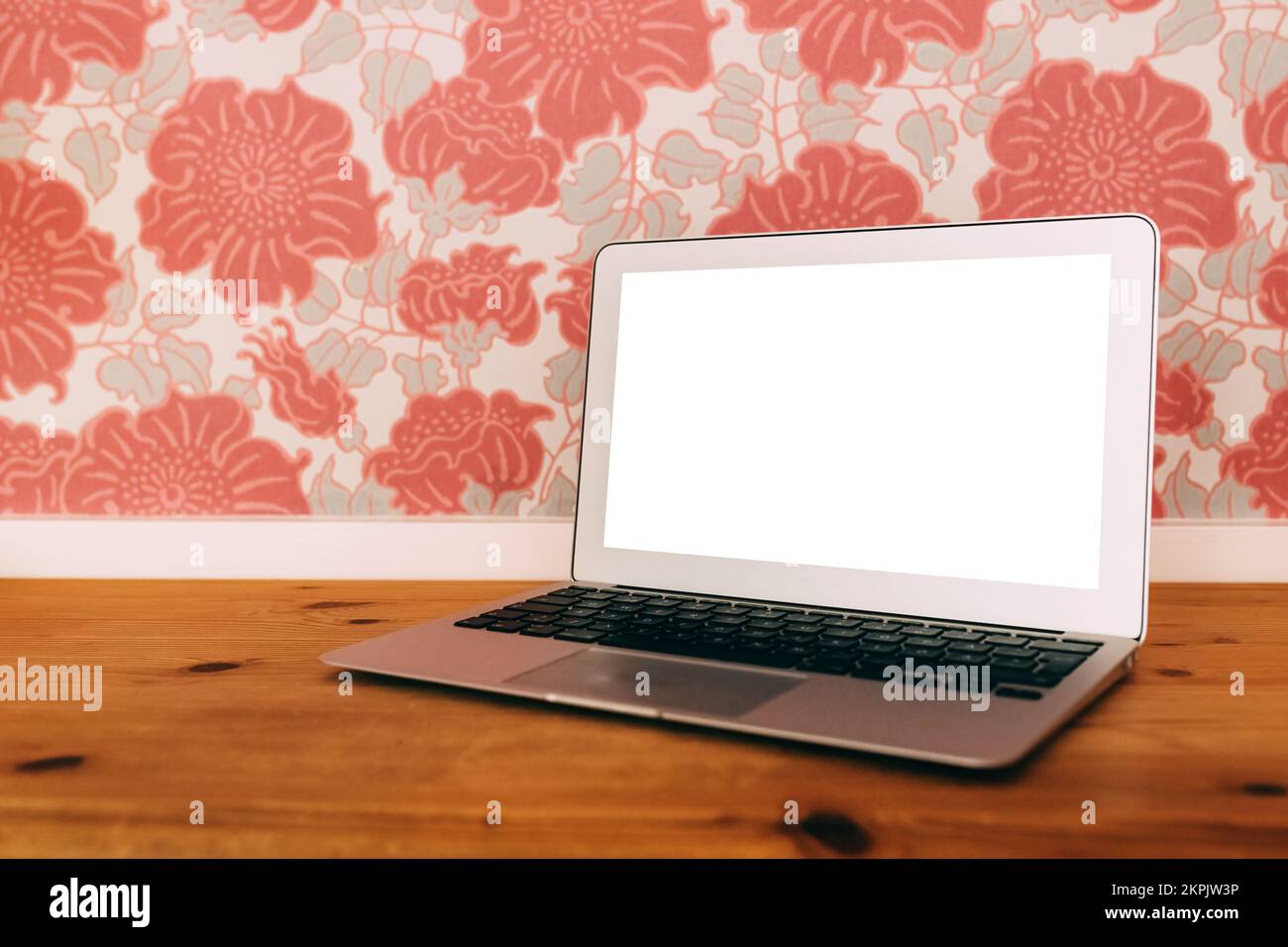 Laptop-Computer mit leerem Mockup-Bildschirm auf dem Wohnzimmerschreibtisch, selektiver Fokus Stockfoto