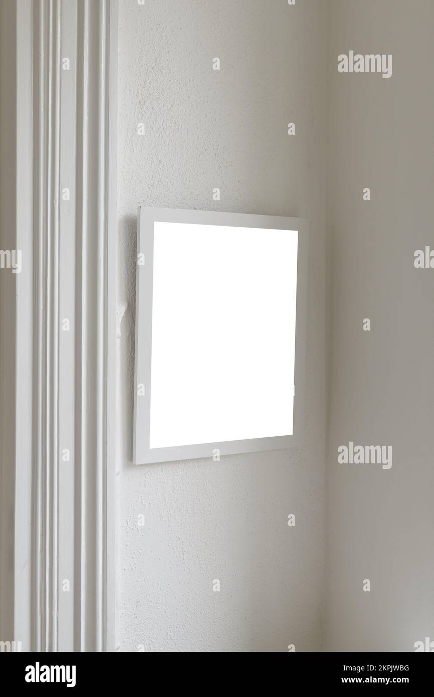 Weißer Bilderrahmen aus Holz mit Mockup-Platz für Fotos, der an der Wohnzimmerwand hängt, selektiver Fokus Stockfoto