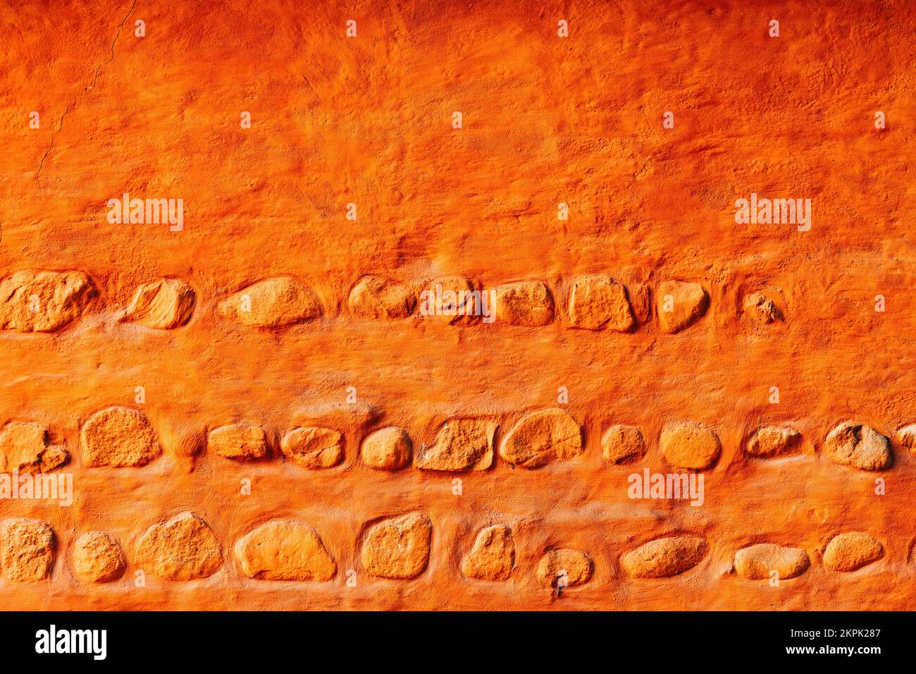 Alte orangefarbene Mauer mit Felsen, Hintergrund im skandinavischen Architekturstil Stockfoto