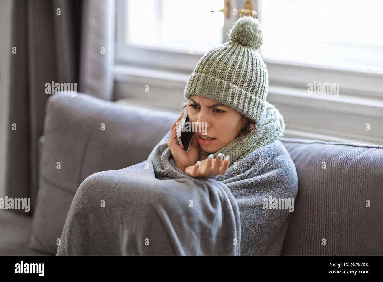 Eiskalte Junge Frau, Die Zu Hause Telefoniert Stockfoto