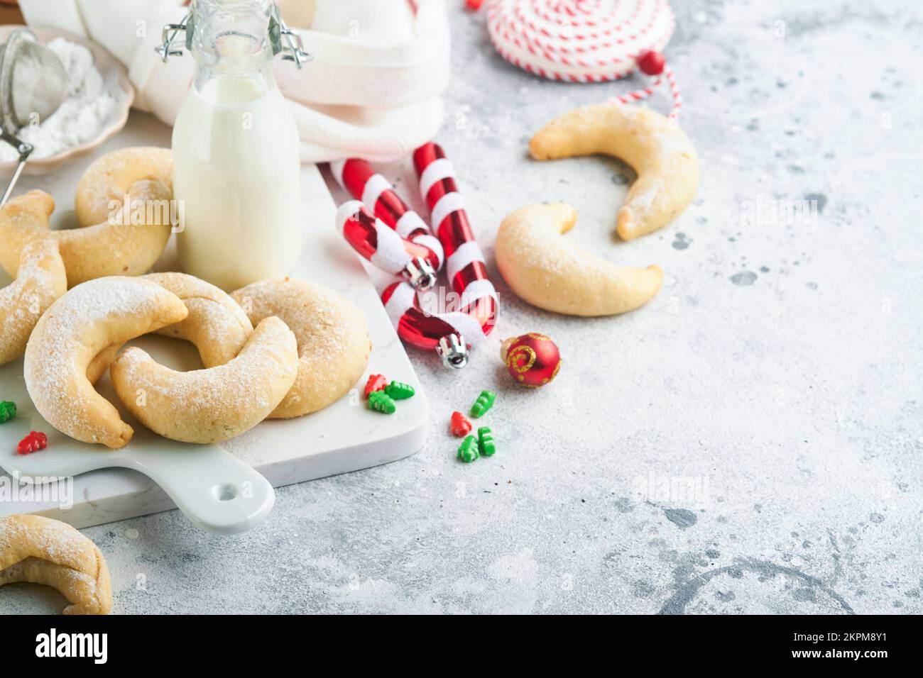 Weihnachtsplätzchen Crescents. Hausgemachte traditionelle Weihnachtskekse Vanillekies in rustikalem Teller mit weihnachtsdekorationen auf grauem alten Backgroun Stockfoto
