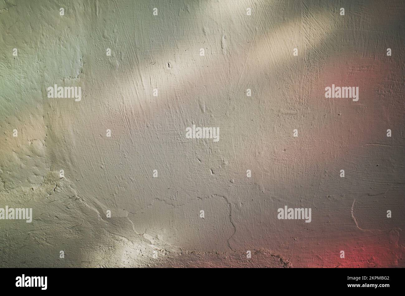 Farbenfrohes Licht aus einem Buntglasfenster, das auf eine Kirchenwand scheint Stockfoto