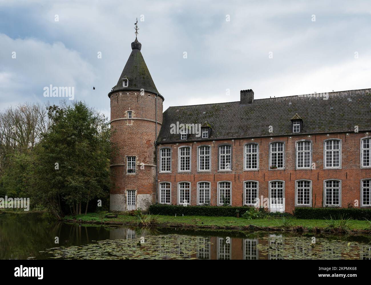 Ternat, Flämische Brabant-Region, Belgien, 11 04 2022 - Turm und Fassade des Steinmauers Schloss Kruikeburg und Teich Stockfoto
