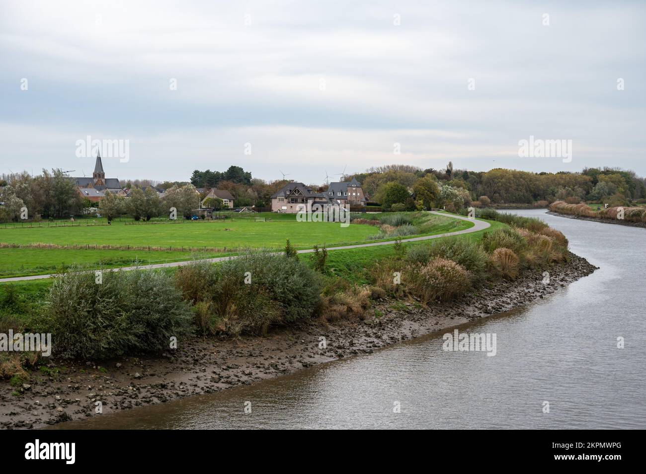 Berlare, Ostflämische Region, Belgien - Blick auf die Schelde, Vegetation und das Dorf im Hintergrund Stockfoto