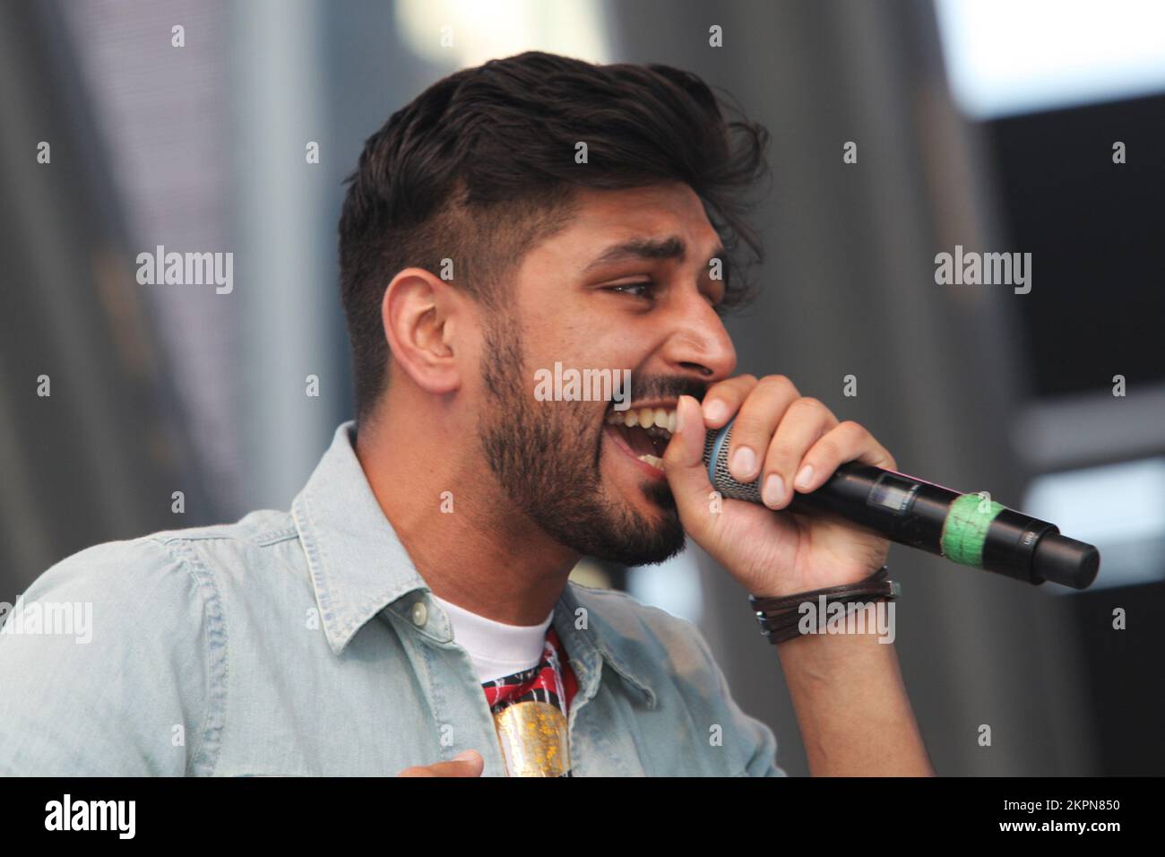 August 2013, Mississauga, Ontario, Kanada. --- Leadsänger Sups der britischen Band Swami belebt das Publikum, während Swami beim Mosaik 2013 South Asian Heritage Festival in Mississauga auftritt. Swami kombiniert Punjabi, Hindi und Englisch und kombiniert Bhangra, Rock und Rap zu einem einzigartigen Musikstil, der sich im gesamten Vereinigten Königreich ausgebreitet hat. Ihr Sound ist eine perfekte Hommage an die unabhängige Punjabi-Musik, die sich in Großbritannien in den letzten 30 Jahren entwickelt hat. --- (Foto von Creative Touch Imaging Ltd./NurPhoto) Stockfoto