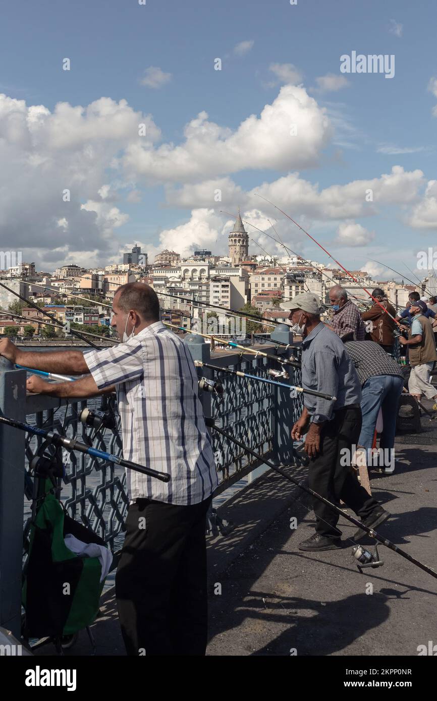 Blick auf viele Fischer auf der Galata-Brücke in Istanbul. Der Galata-Turm und das Viertel Beyoglu sind im Hintergrund. Das Bild spiegelt den Lebensstil und die Kultur von wider Stockfoto