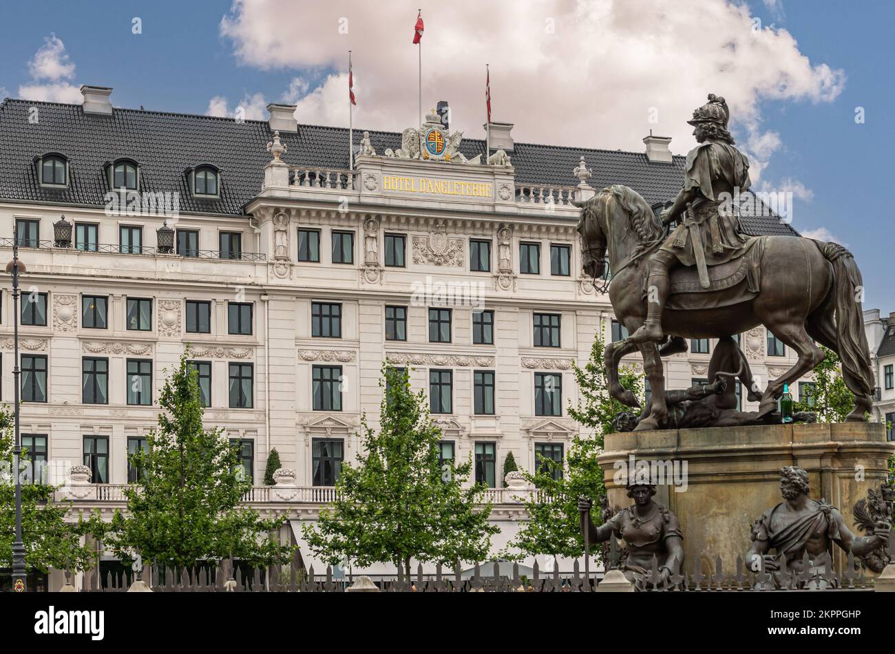 Kopenhagen, Dänemark - 23. Juli 2022: Schwarze Bronzestatue des Reiters Christian V. auf Kongens Nytorv, vor dem historischen weißen Hotel D'Angleterre Stockfoto