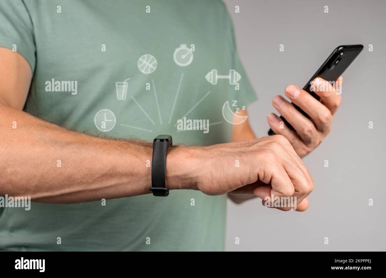 Mit fitbit, Fitnessarmband und Mobiltelefon. Hände mit Sport-Smartwatch und Smartphone für Synchronisation. Hochwertiges Foto Stockfoto