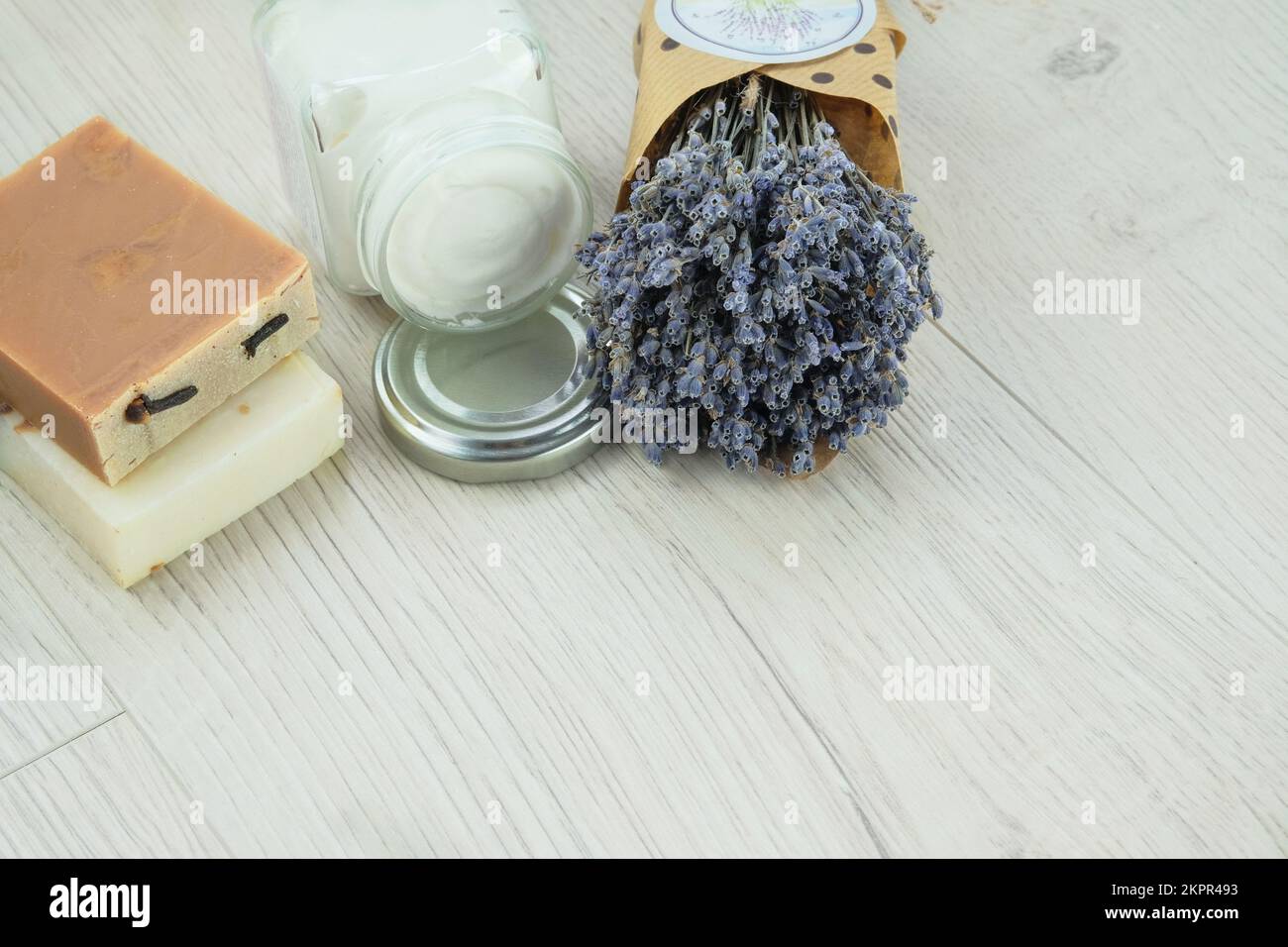 Handgefertigte kosmetische Cremebecher, Seife und getrocknete Lavendelblumen auf hellem Hintergrund. Bio-organische Kosmetik. Pflanzenbasis. Stockfoto