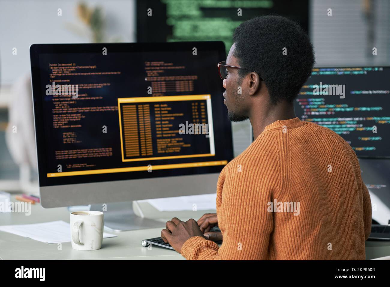 Programmer findet und behebt Probleme mit Code auf dem Computerbildschirm Stockfoto