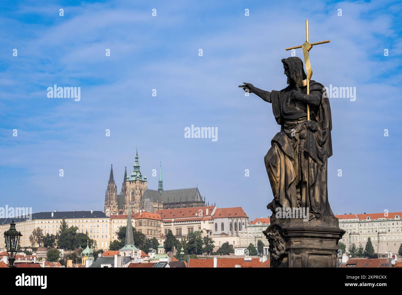 Prag, Tschechische Republik - 5. September 2022: Statue auf der Karlsbrücke und Prager Burg im Hintergrund Stockfoto