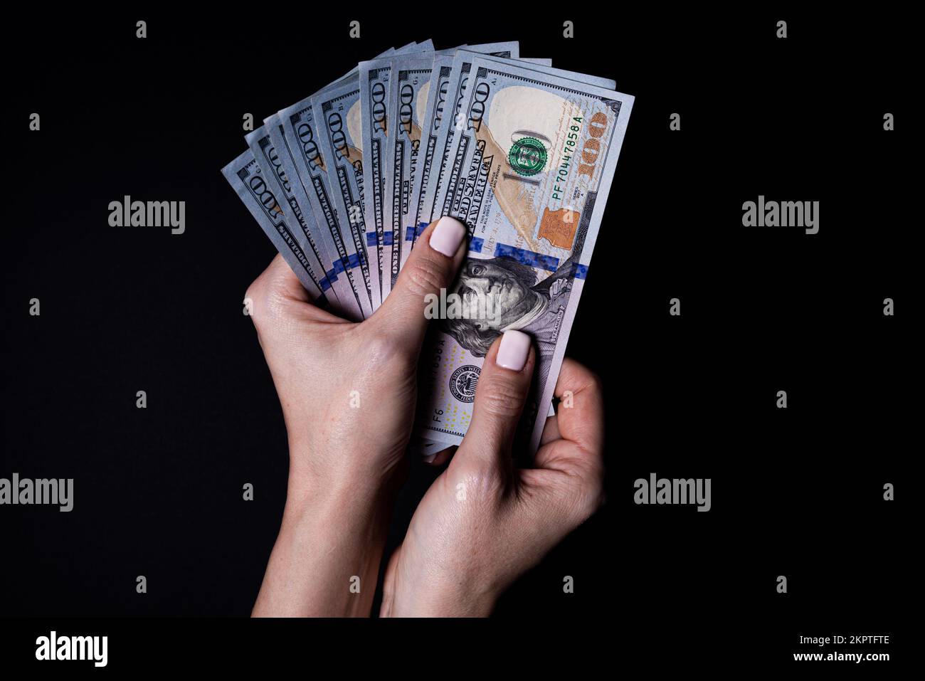 Zwei Hände mit Dollar. Nahaufnahme weibliche Hand gibt Geld für etwas mit isoliertem schwarzen Hintergrund, zählen, zahlen, mit Dollar einkaufen, korrupten Stockfoto