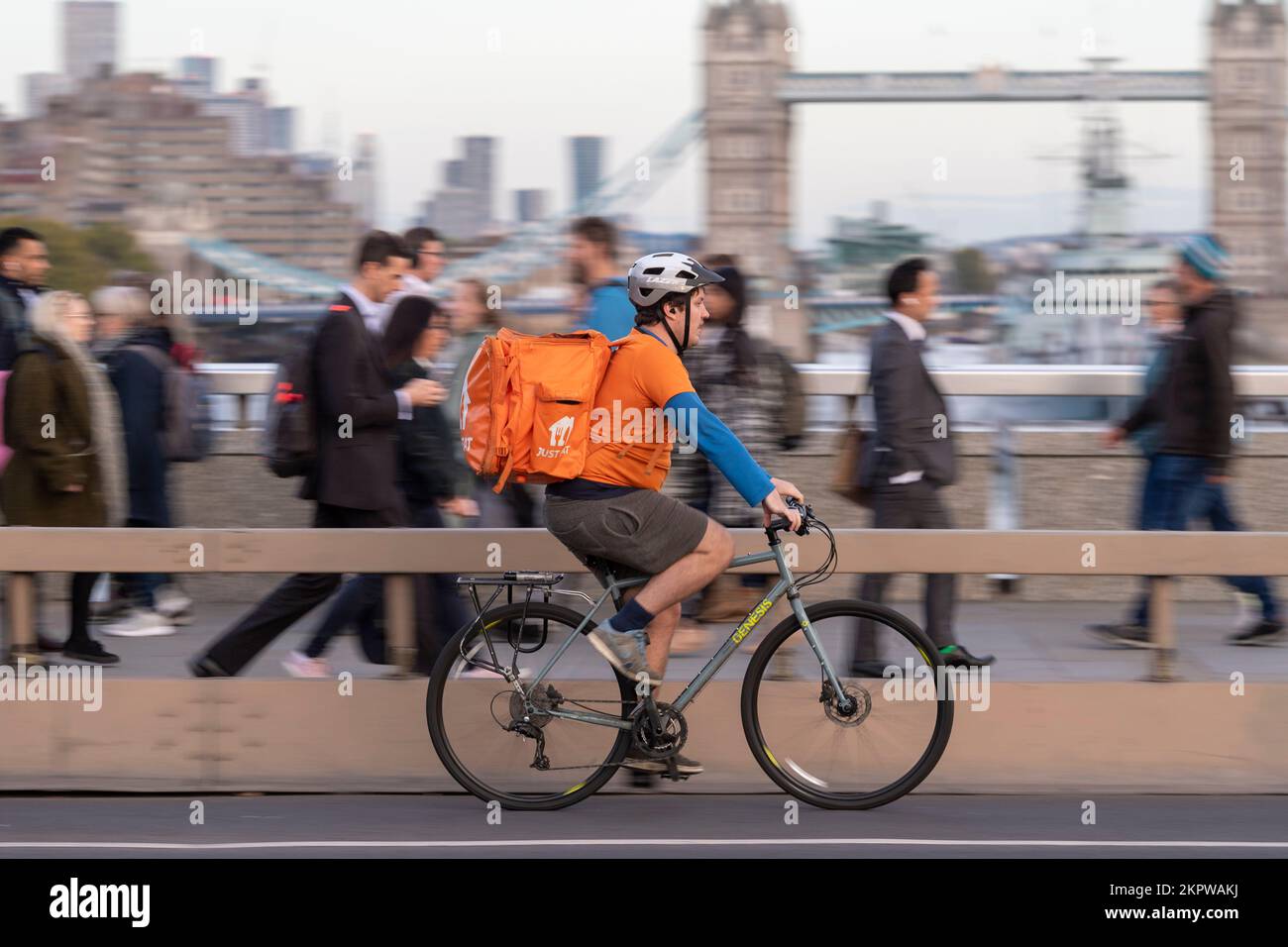 Ein Fahrrad-Kurier, der mit dem E-Bike über London Bridge fährt, London, Großbritannien. 18. Okt. 2022 Stockfoto