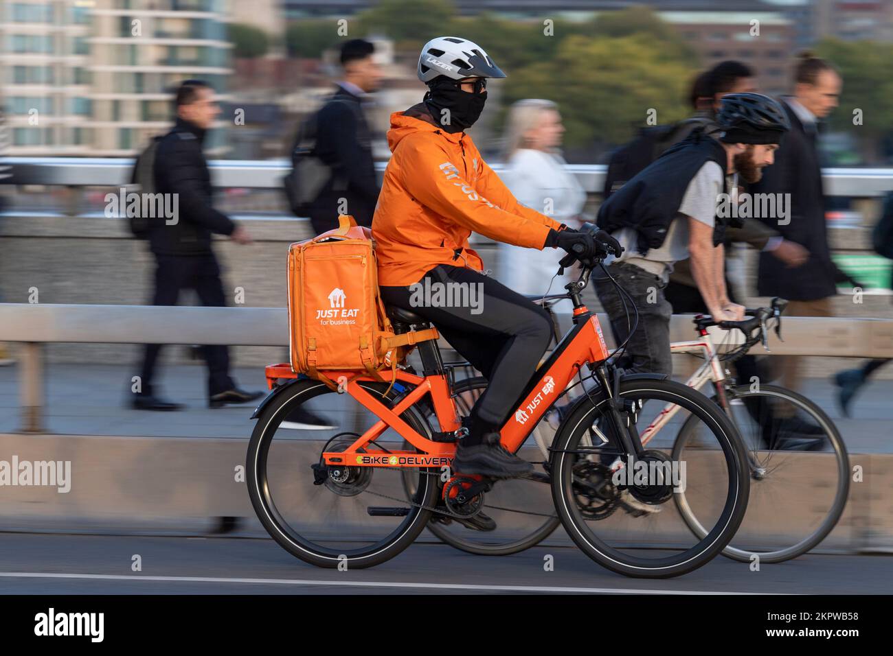 Ein Fahrrad-Kurier, der mit dem E-Bike über London Bridge fährt, London, Großbritannien. 17. Okt. 2022 Stockfoto
