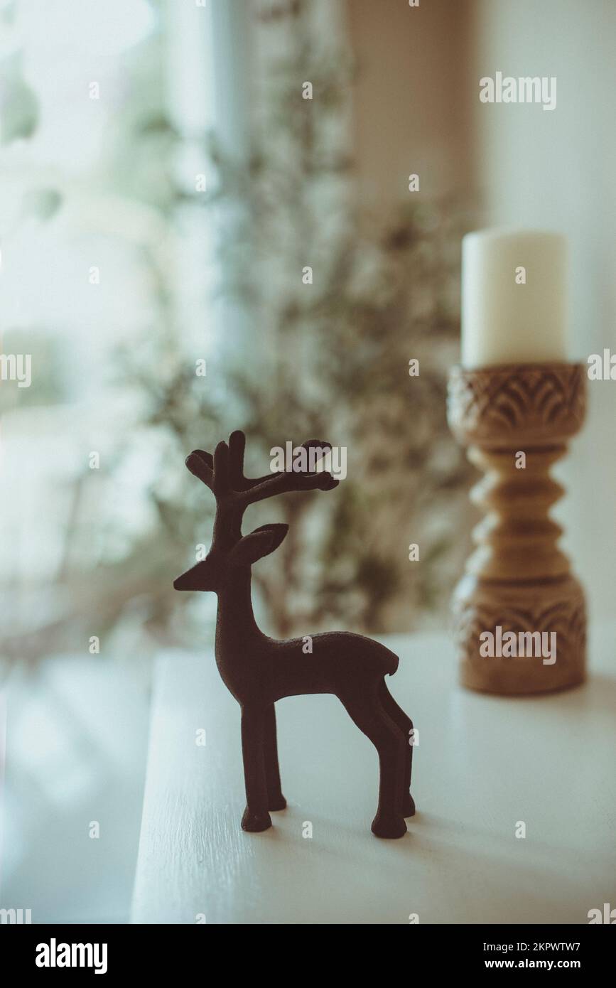 Weihnachtsdekoration mit Rentieren neben einem Kerzenhalter auf einem Tisch Stockfoto