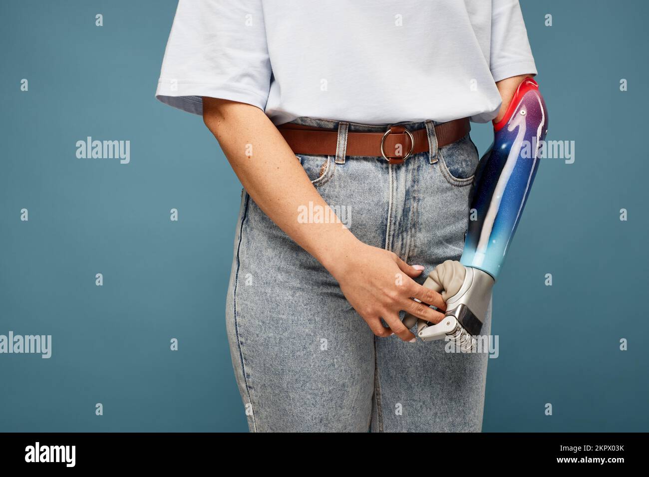 Zugeschnittenes Bild einer Frau mit Armprothesen vor blauem Hintergrund Stockfoto