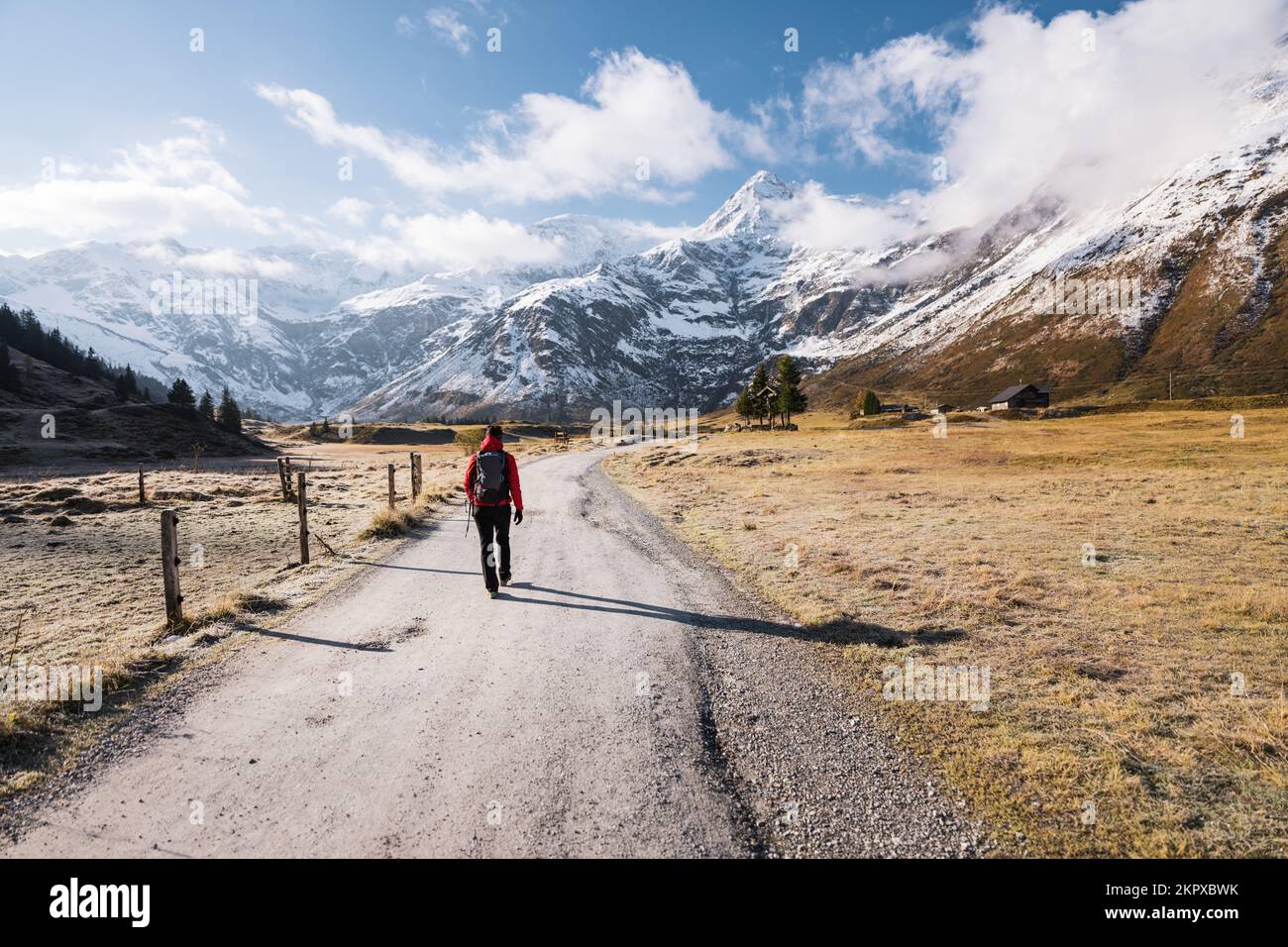 Rückansicht einer Frau auf einem alpinen Fußweg in Richtung Berge, Gastein, Salzburg, Österreich Stockfoto