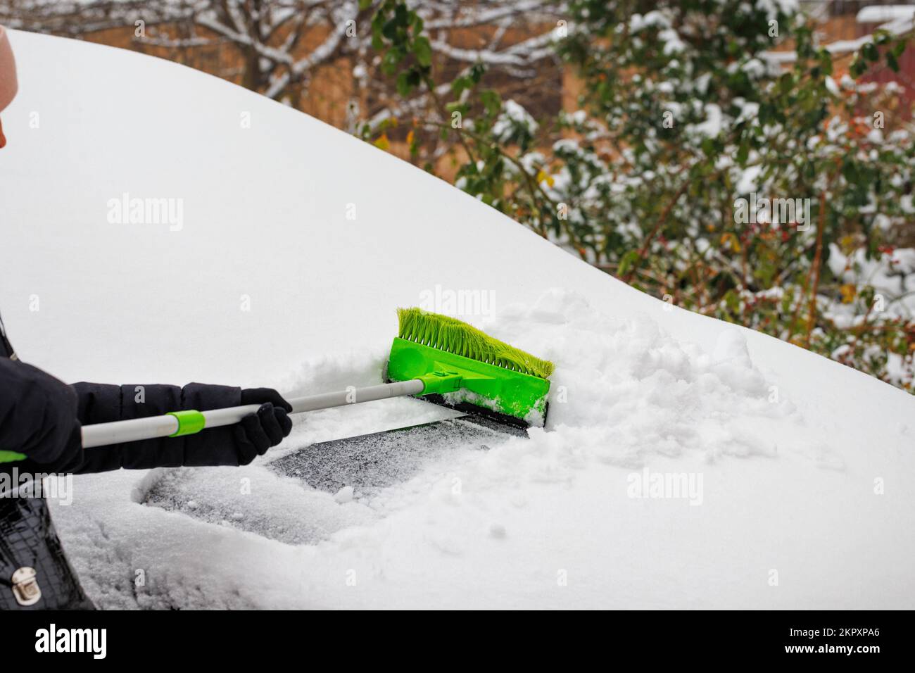 Frau reinigt ihr Auto von Eis und Schnee Stockfotografie - Alamy