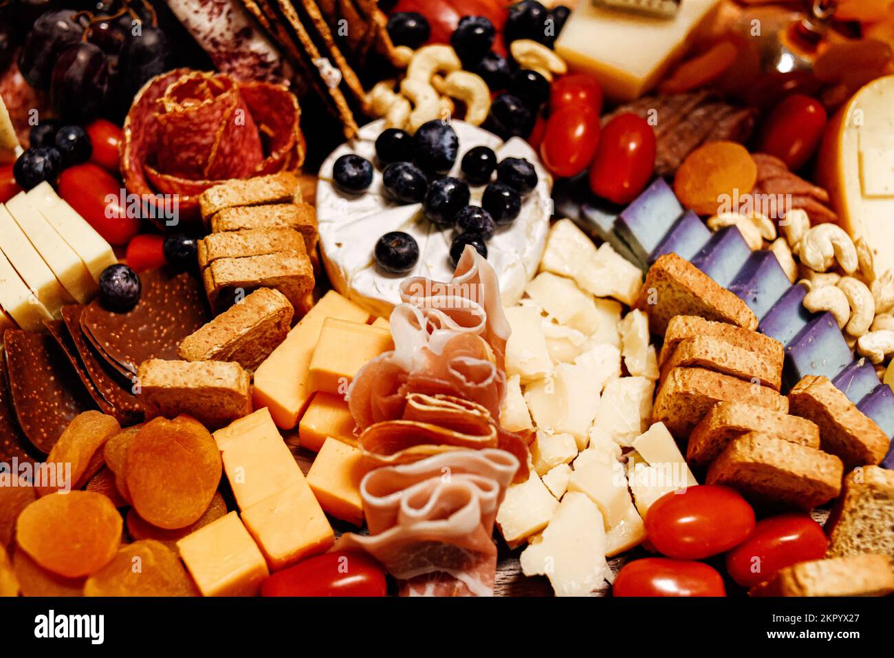 Käseplatte, Käseplatte, Fleisch und Brett. Gemüse und Obst mit Käse und Schokolade, Prosciutto und Salami mit Brot. Großes Snackboard für Stockfoto