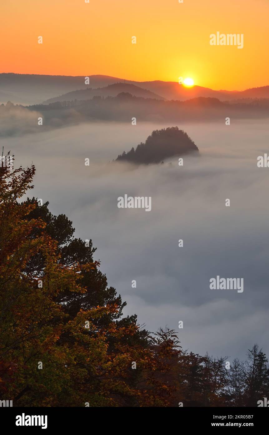 Schöne und einzigartige Berglandschaft. Die Sonne, die hinter den Hügeln in der Morgenlandschaft aufgeht. Foto aufgenommen in Sokolica Peak, Polen. Stockfoto