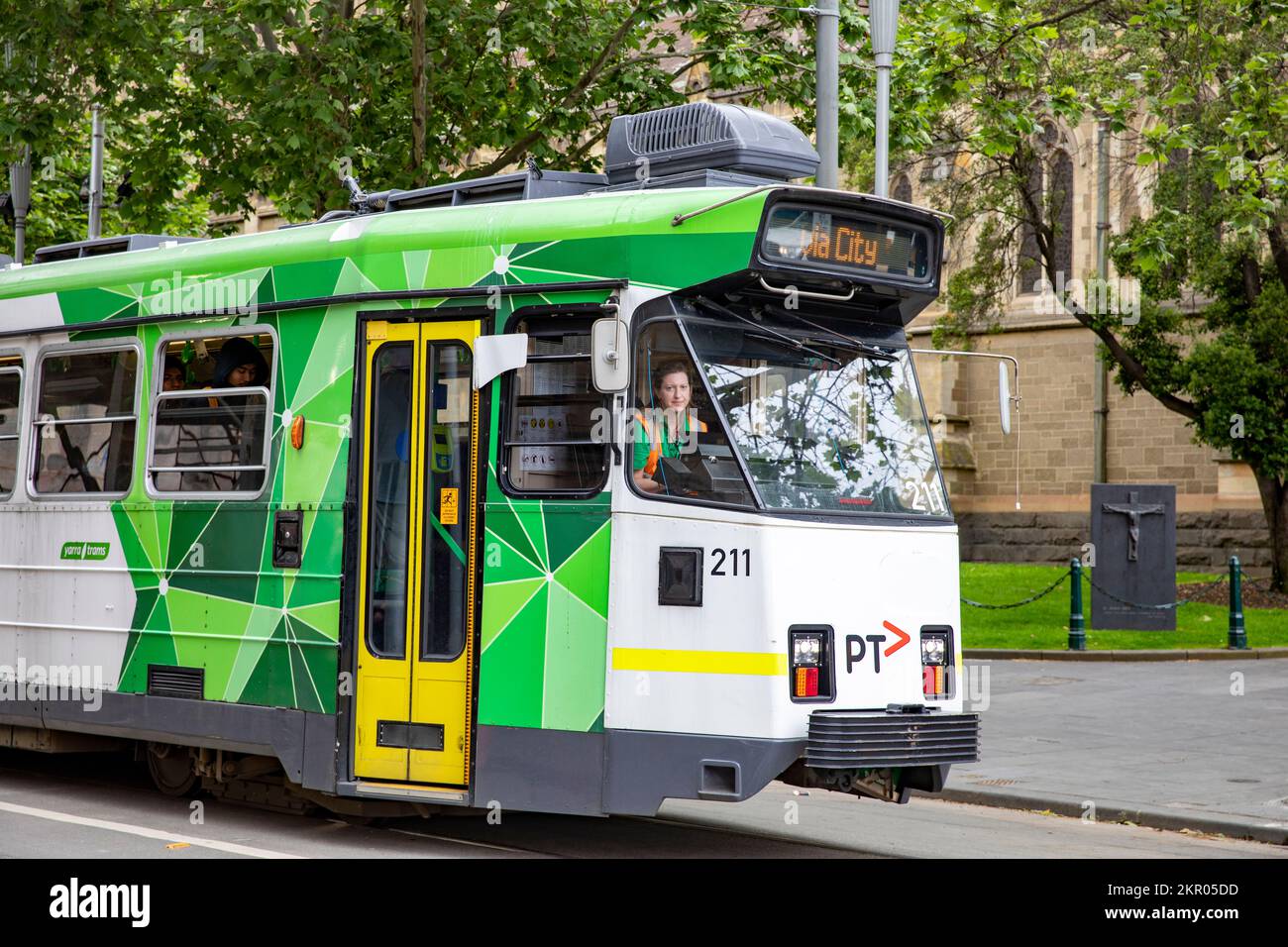 Eine australische Frau, die mit einem Straßenbahnfahrzeug in Melbourne im Stadtzentrum, Victoria, Australien fährt Stockfoto