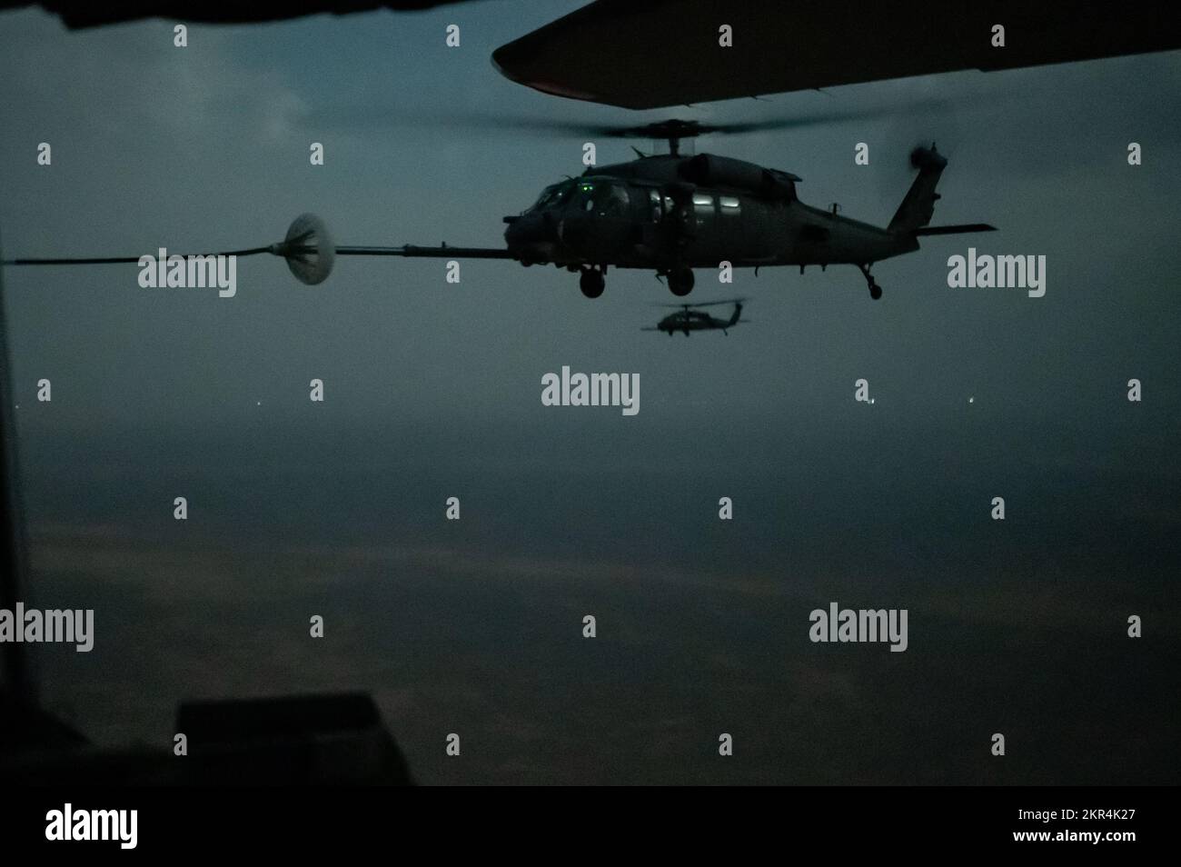 EIN US-AMERIKANISCHER Air Force HH-60G Pave Hawk erhält Treibstoff von einem HC-130J Combat King II, der der 1. Expeditionary Rescue Group während einer nächtlichen Hubschrauber-Luft-Tankmission (HAAR) innerhalb der USA zugeteilt wurde Verantwortungsbereich des Zentralkommandos, 7. November 2022. Die Hauptaufgabe des Pave Hawk besteht darin, Tag und Nacht Kampfsuche und -Rettung sowie Personalwiederherstellungsoperationen in feindlichen Umgebungen durchzuführen, die die Wiederherstellung von isoliertem Personal während Konflikten ermöglichen. HAAR Operations fungiert als Kraftausweiser und hält Rettungskräfte länger in der Luft. Stockfoto