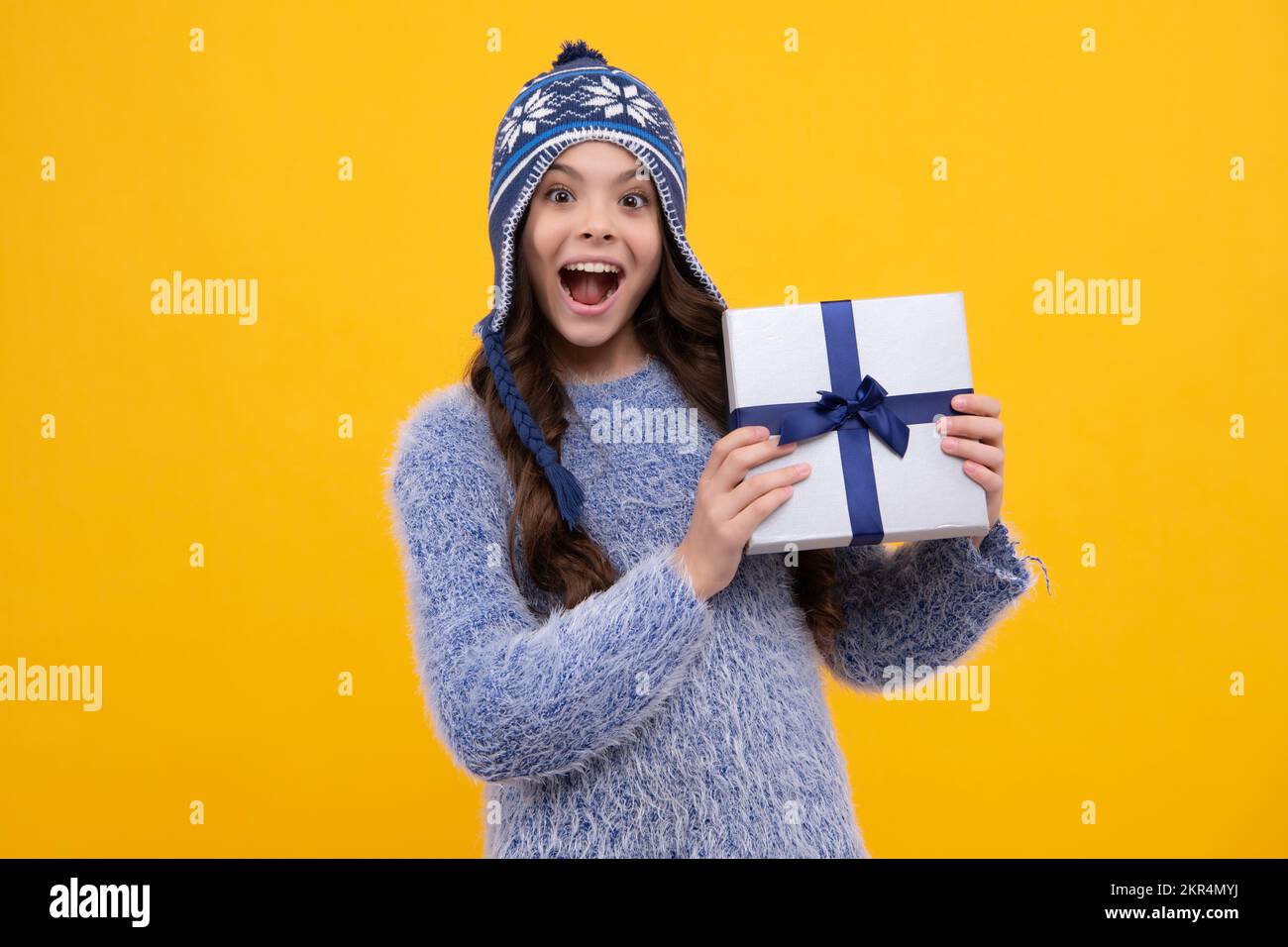 Emotionale Teenager Kind halten Geschenk am Geburtstag. Lustige Kind Mädchen halten Geschenkboxen feiern frohes neues Jahr oder Weihnachten. Aufgeregt Teenager Mädchen. Stockfoto