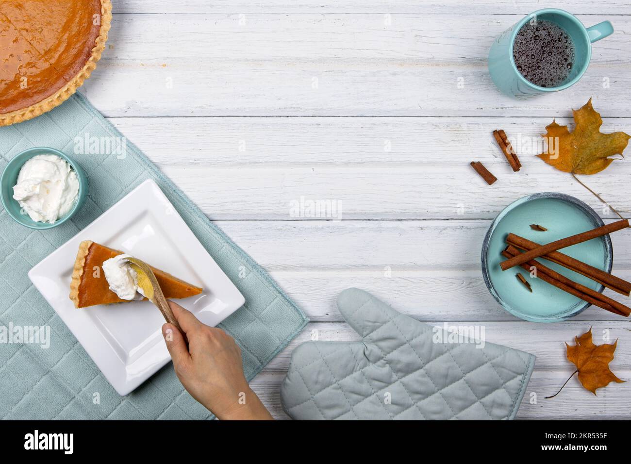 Ein flach liegendes Foto mit Platz für Text wie Schlagsahne auf ein Stück Kürbiskuchen und verschiedene verwandte Objekte. Stockfoto