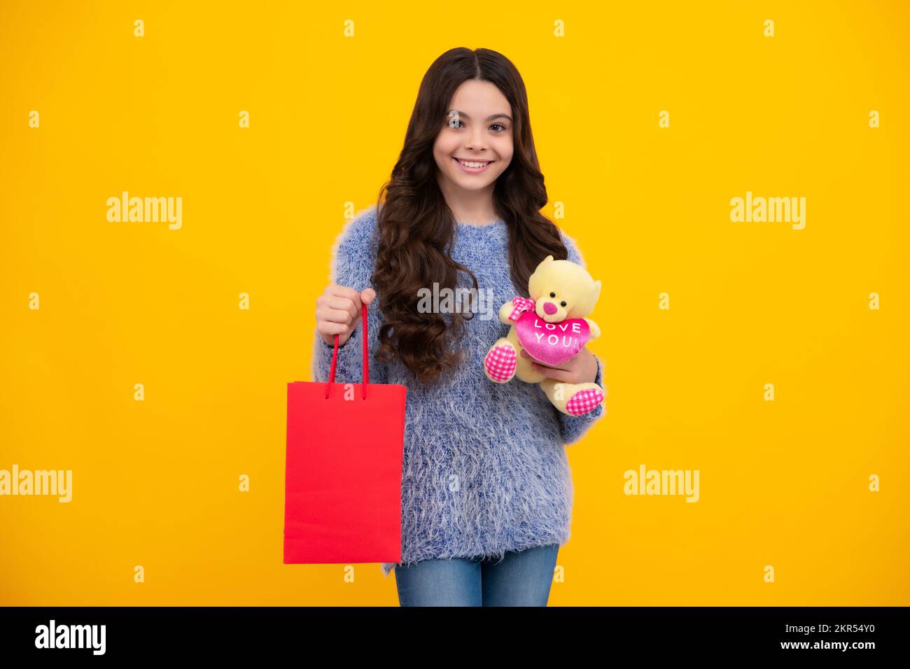 Schöne Mode Teenager Mädchen mit Einkaufstaschen auf gelbem Hintergrund. Shopaholic Shopping und Mode. Kind mit Einkaufstaschen. Glücklich Stockfoto