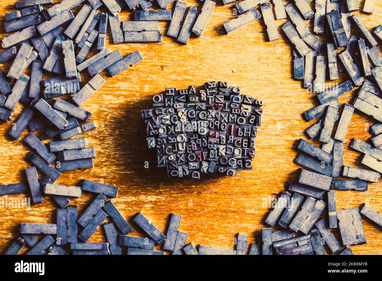 Retro-Industriedrucker legen das Buchdruckkonzept auf eine Streuung von Satzblöcken mit verschlungenem Buchstaben und Zahlen. Vintage Writers Block Stockfoto