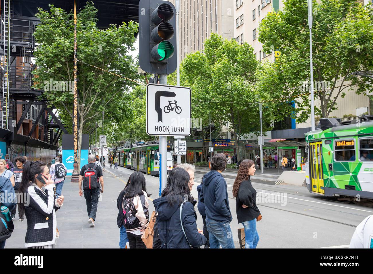 Hook Turn Road Rule Schild im Stadtzentrum von Melbourne, Fahrzeuge und Fahrräder biegen von der linken Spur rechts ab, Melbourne Tram fährt vorbei, Victoria, Australien Stockfoto