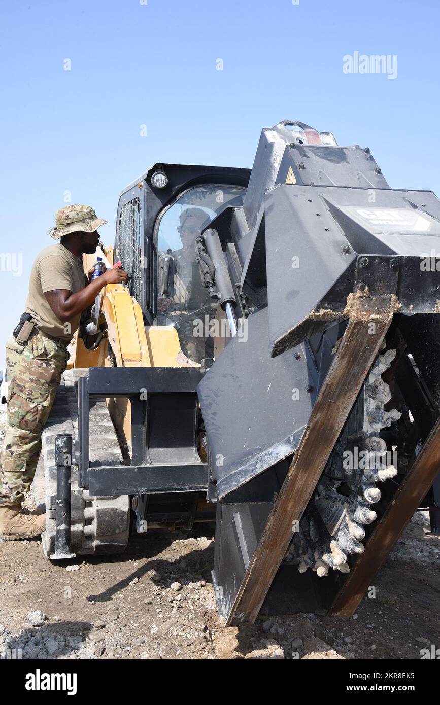 USA Air Force Airman First Class D’Andre Dunkley, 380. Expeditionary Civil Engineer Squadron (ECES) Heavy Equipment Shop Lehrling, unterrichtet andere Mitglieder der ECES 380. über die Bedienung des Kompaktladers mit Betonsäge während der RADR-Schulung (Rapid Airfield Damage Repair) am Luftwaffenstützpunkt Al Dhafra. Vereinigte Arabische Emirate, 10. November 2022. Die Mitglieder des ECES 380. mussten sich durch mehrere Stationen abwechseln, um die Bedienung der schweren Geräte zu erlernen, darunter Kipplaster, Bagger, biometrische Mischer und mehr. Stockfoto