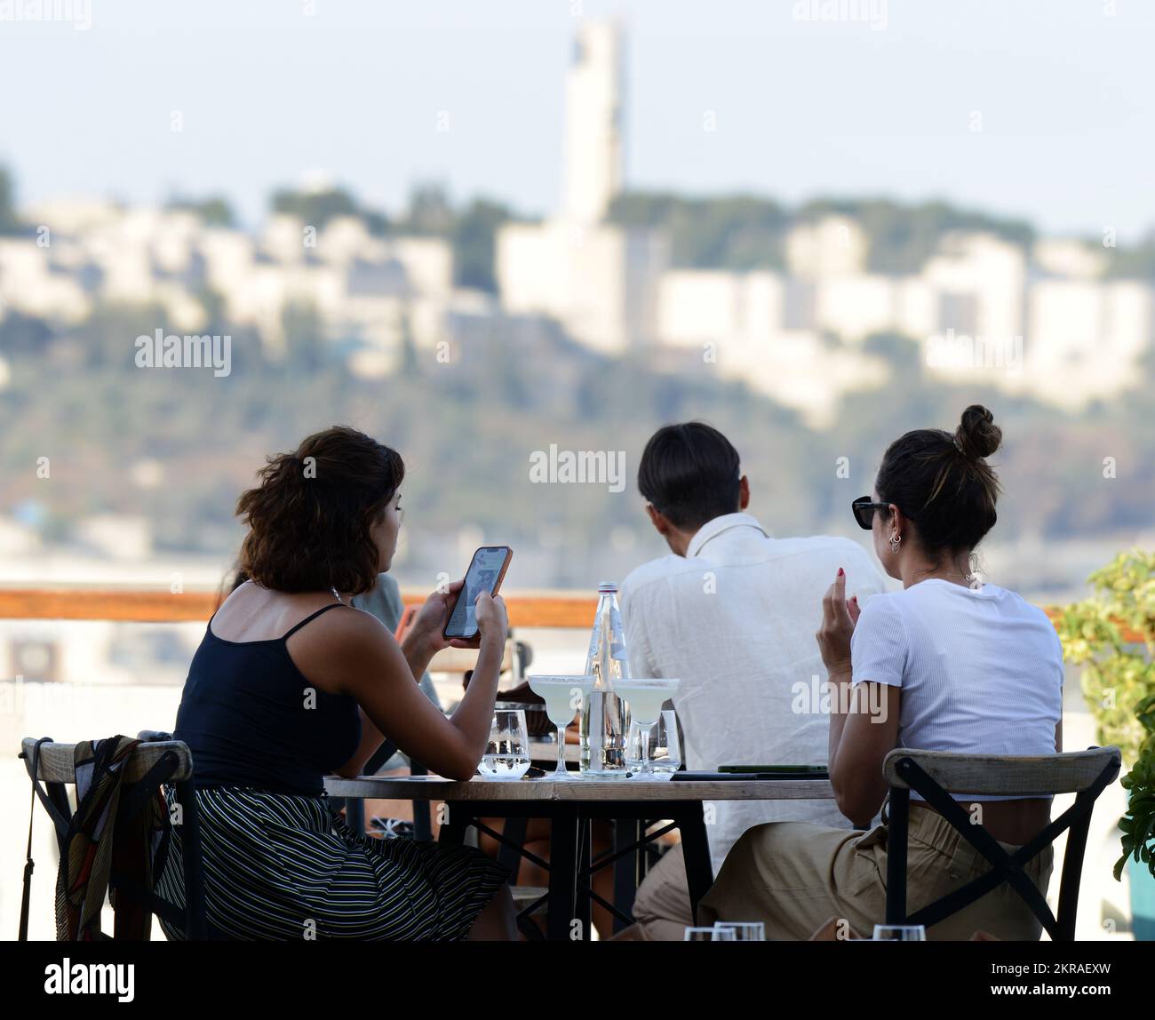 Touristen genießen den Blick auf die Stadt vom Restaurant auf der Dachterrasse mit Wein und Käse im Notre Dame von Jerusalem. Jerusalem, Israel. Stockfoto