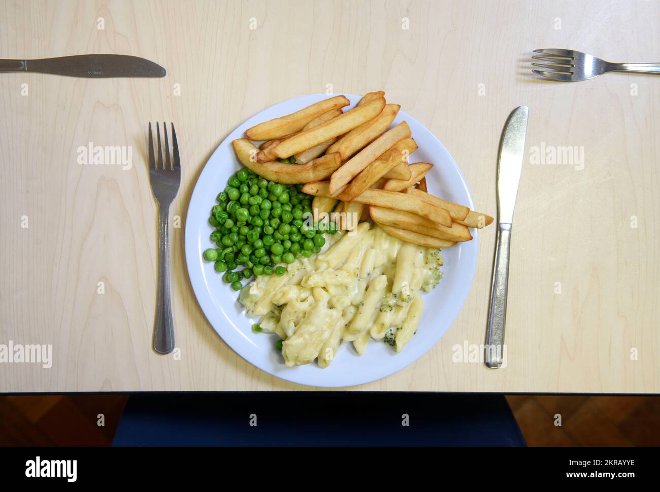 Schulessen: Käse und Brokkoli-Pasta mit Pommes Frites. Stockfoto